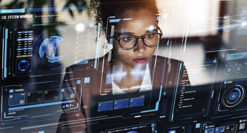 Eine junge Frau mit Brille sitzt vor einem Computer.