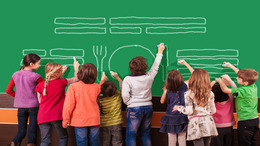 Eine Gruppe von neun Kindern mal mit Kreide auf die Schultafel.