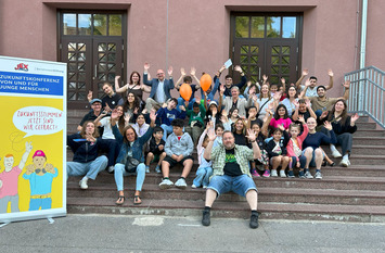Foto mit mehreren Personen, die lachend in die Kamera schauen. Entstanden bei der Konferenz
