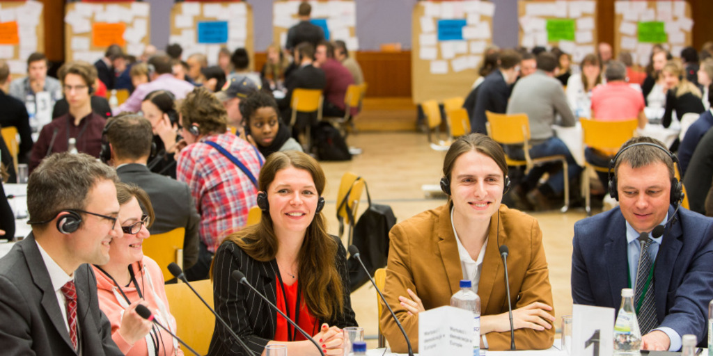 Menschen diskutieren an runden Tischen