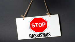 Ein Stopschild, darunter steht der Begriff "Rassismus"