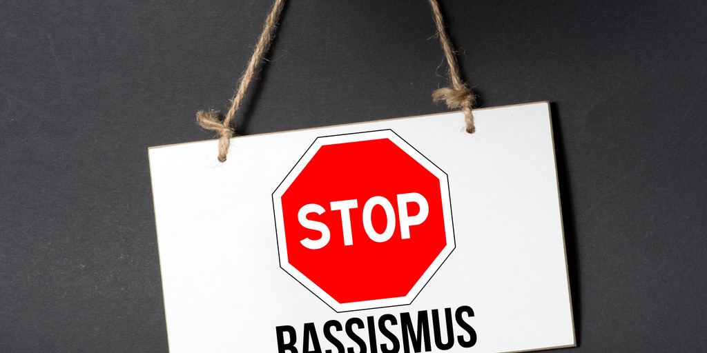 Ein Stopschild, darunter steht der Begriff "Rassismus"