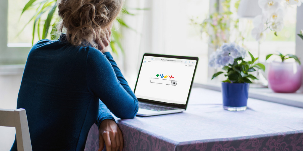 A woman is looking on a laptop on which she has opened a search engine website.