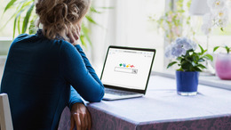 A woman is looking on a laptop on which she has opened a search engine website.