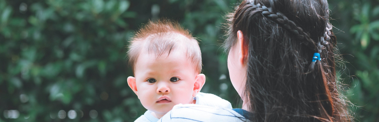 Ein Kind auf dem Arm seiner Mutter