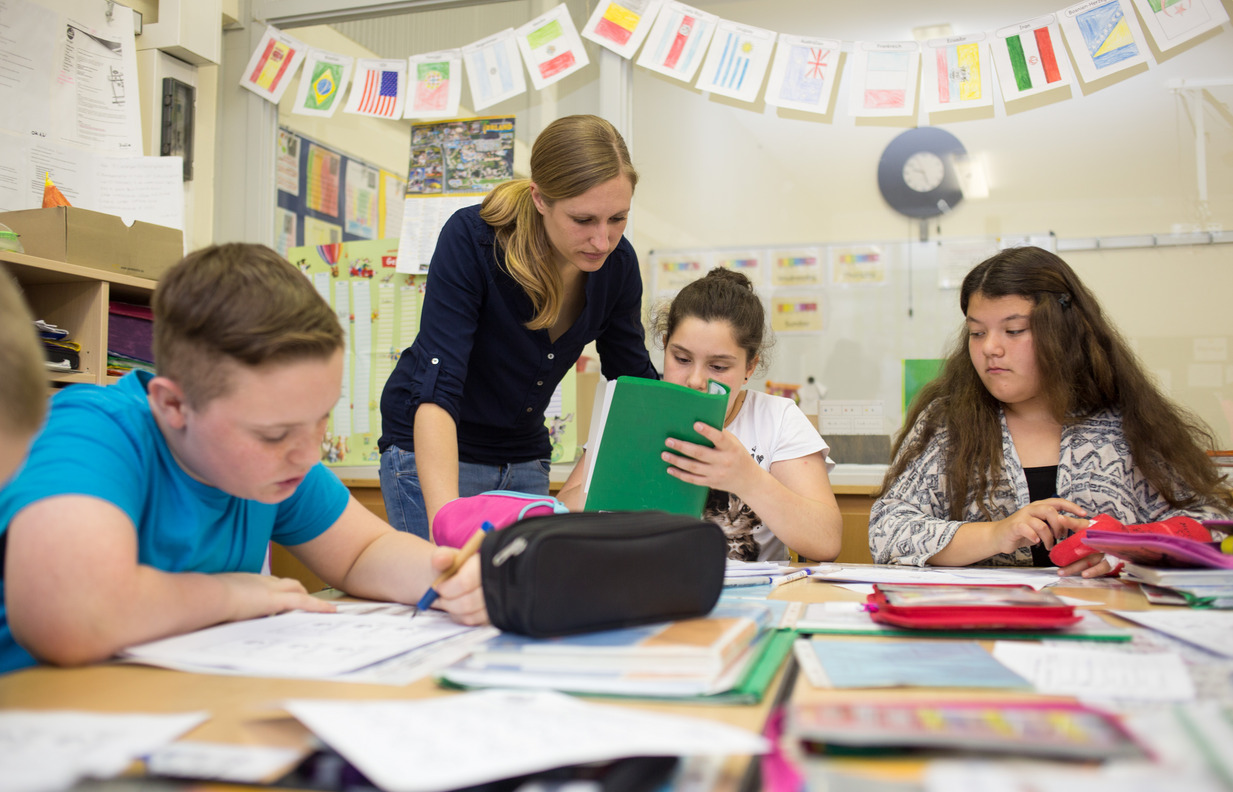 Individuelle Förderung - die Klassenlehrerin unterstützt einzelne Schüler bei der Bearbeitung ihrer Aufgaben