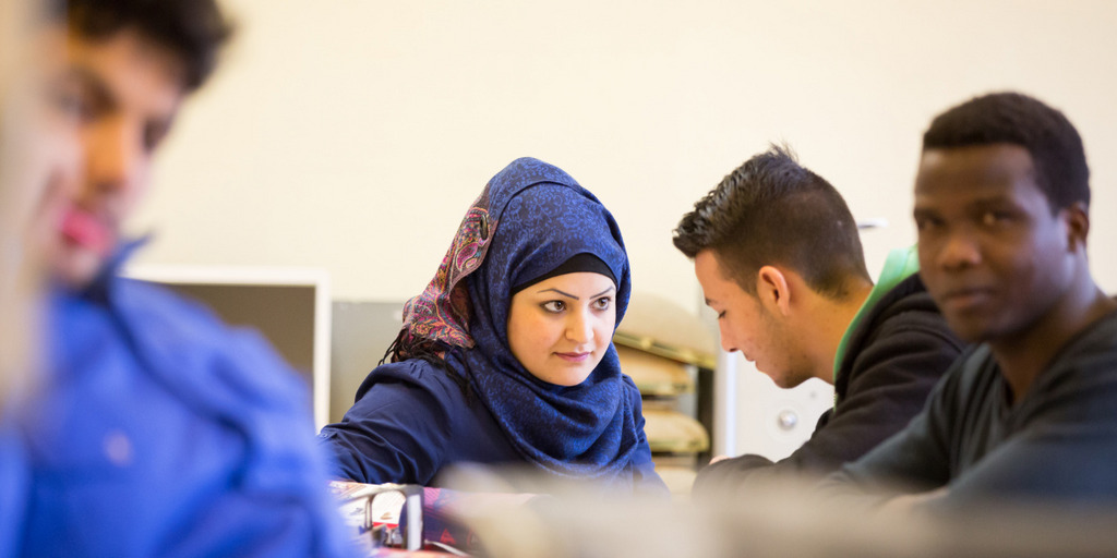 Vier Flüchtlinge - eine Muslima mit Kopftuch und drei Afrikaner - sitzen in einer Klasse der Berufsschule Lüchow und diskutieren.