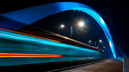 Beleuchtete Straßenbahnbrücke bei Nacht. Straßburg. Fahrende Straßenbahn.