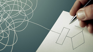 Eine Hand die ein komplexes Diagramm zeichnet.