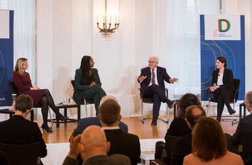 Bundespräsident Frank-Walter Steinmeier sitzt in einem Halbkreis mit den drei Diskussionsteilnehmerinnen und spricht.