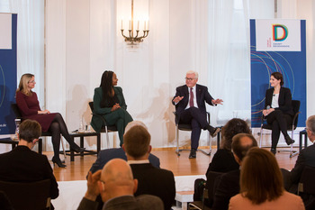 Bundespräsident Frank-Walter Steinmeier sitzt in einem Halbkreis mit den drei Diskussionsteilnehmerinnen und spricht.