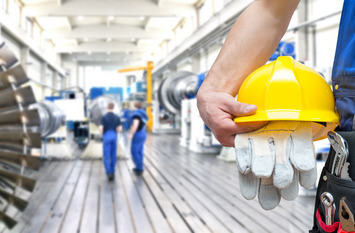 Handwerker mit Helm in der Hand.