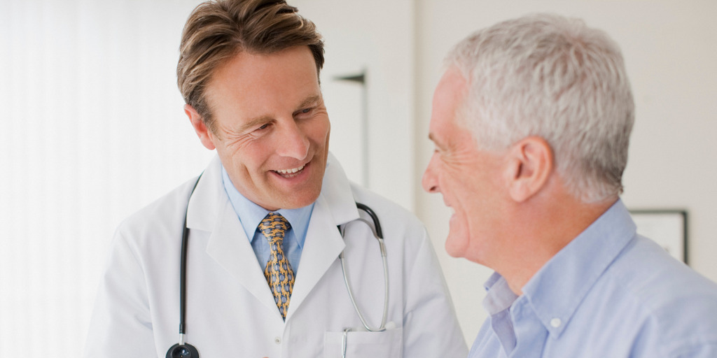 Arzt im Gespräch mit älterem Patienten