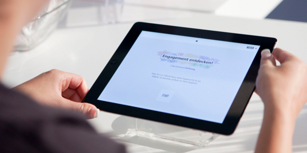 Eine Frau benutzt am Stand der Bertelsmann Stiftung auf dem Bürgerfest des Bundespräsidenten am 6. September 2014 in Berlin auf einem Tablet-PC die App "Welcher Engagement-Typ sind Sie?"