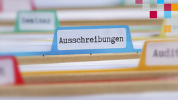 Nahaufnahme einer Hängetasche in blau mit der Aufschrift "Ausschreibungen"