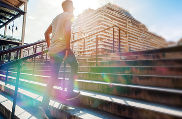 Junger Mann geht in der Stadt eine Treppe hoch