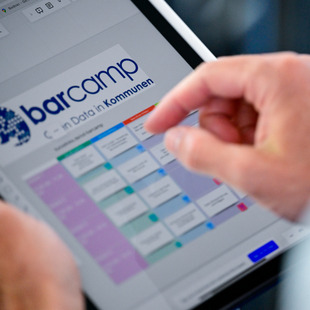 Teilnehmer informiert sich über das Barcamp anhand eines Ipads.