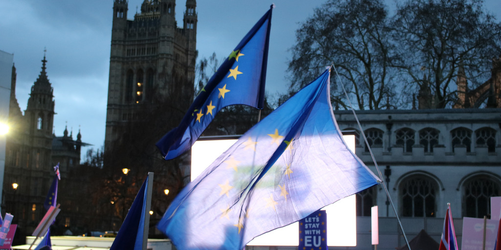 Brexit opponents wave European flags during a demonstration near the British Houses of Parliament in London. Meanwhile, they watch the House of Common's vote on the Brexit plan on a large video screen.