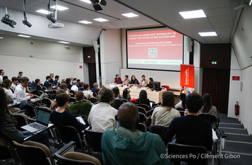 Horsaal an der franzöischen Universität Sciences Po zu sehen. Es findet gerade ein Panel mit vielen Zuschauern statt.