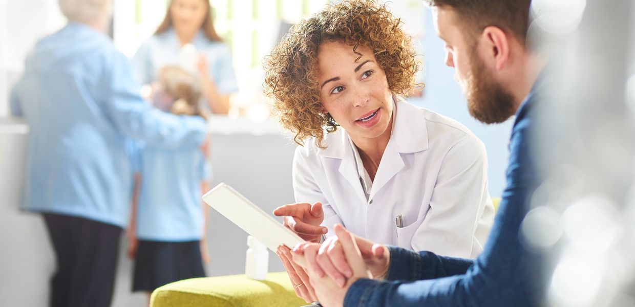 (© sturti/iStockphoto.com) Ärztin und Patient im Gespräch.
