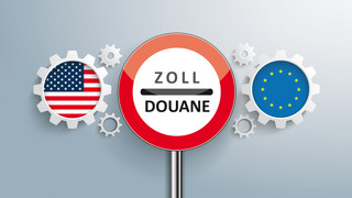 Ein Zoll-Schild zwischen Zahnrädern mit USA- und EU-Flagge