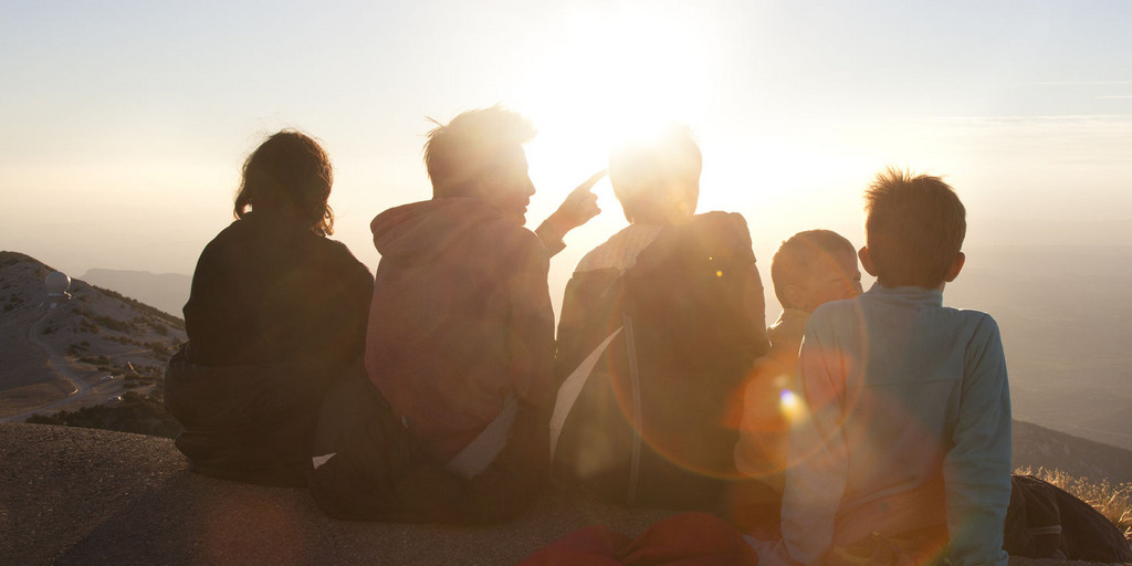 Rückenansicht Jugendlicher vor einem Sonnenuntergang