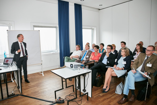 Beim Fachforum zum Thema Bauen/Unterkünfte hören die Teilnehmer einem Vortrag zu.