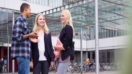 Drei Studenten vor einer Hochschule