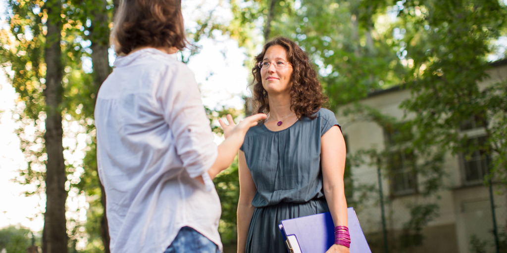 Zwei Mitarbeiter:innen im Dialog in einer KiTa.