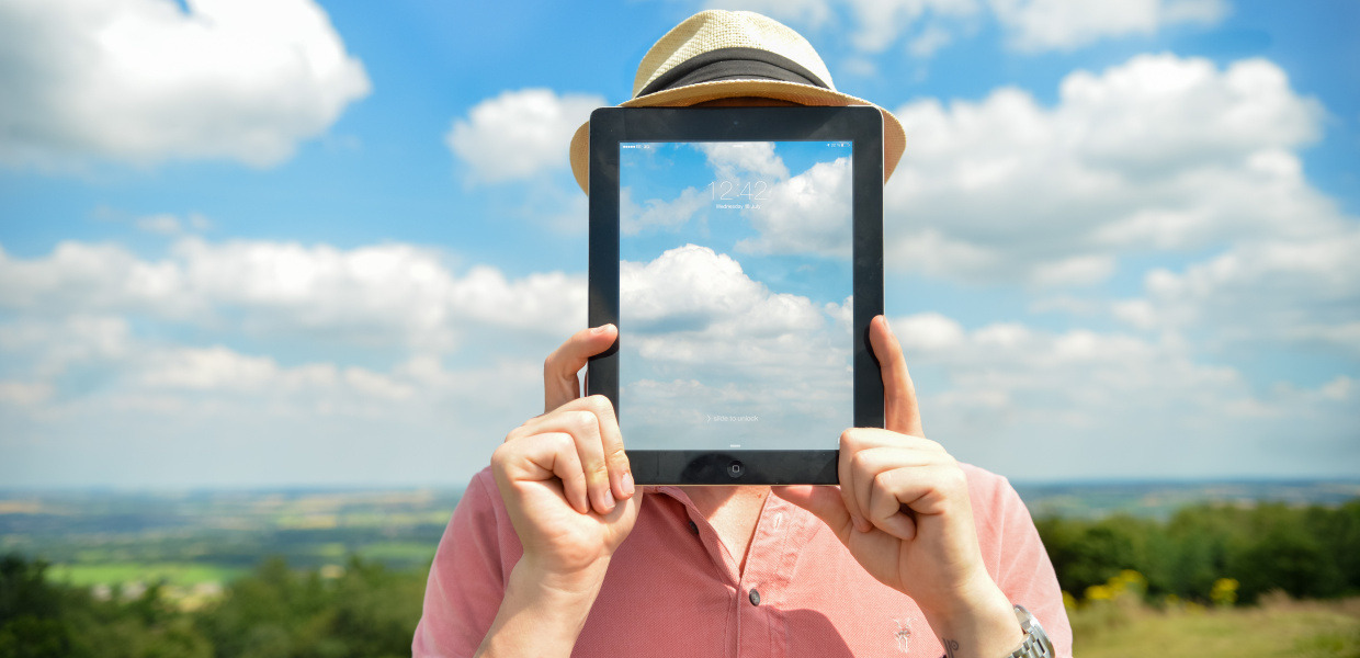 (© Ed Gregory / Stokpic / Pexels - CC0, Public Domain) Porträtbild eines Mannes vor Wolkenhimmel, an Stelle des Gesichts ein durchsichtiges Tablet