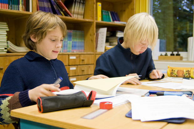 Zwei Schüler der Montessori-Gesamtschule in Borken lernen an einem Tisch.