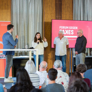 Personen sprechen auf dem Podium