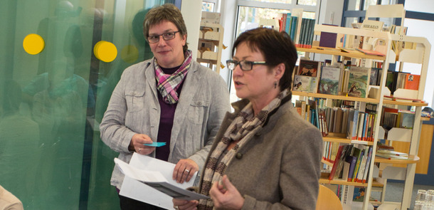 Zwei Frauen stehen vor einer Glaswand und sprechen miteinanderZwei Frauen stehen vor einer Glaswand und sprechen miteinanderZwei Frauen stehen vor einer Glaswand und sprechen miteinanderZwei Frauen stehen vor einer Glaswand und sprechen miteinander