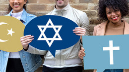 Drei Menschen stehen nebeinander vor einer Mauer und halten je ein Schild mit religiösem Symbol in den Händen