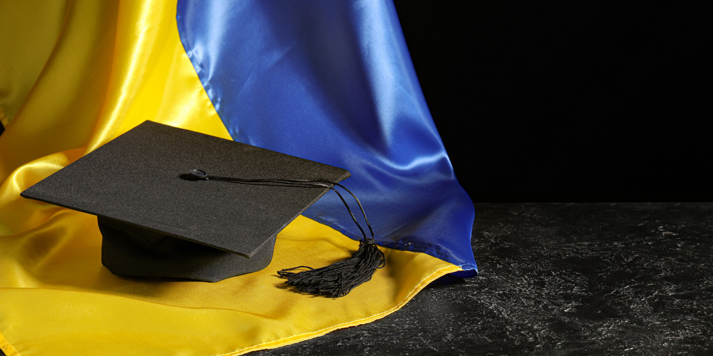 Studentenhut auf einer ukrainischen Flagge
