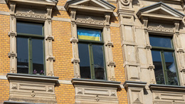 Hausfassade eine Altbaus in Leipzig mit einer Ukraineflagge im Fenster