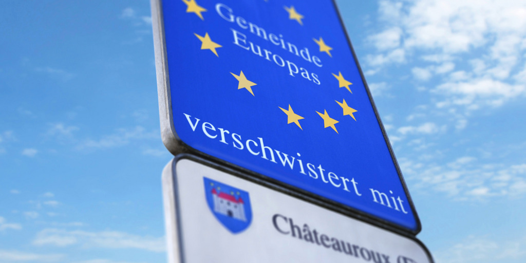 An einem Ortseingang zeigt ein Schild, dass der Ort eine "Gemeinde Europas" ist, die mit einer französischen Gemeinde verschwistert ist.