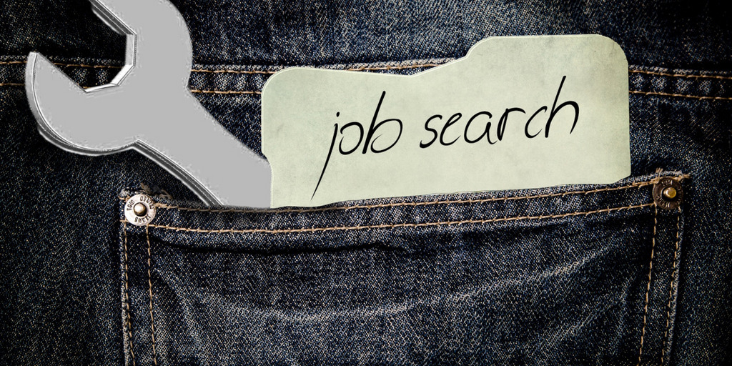 Hosentasche mit Werkzeug und Zettel, auf dem steht, dass ein Job gesucht wird