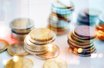 Stapel von Euro- und Cent-Münzen stehen nebeneinander.