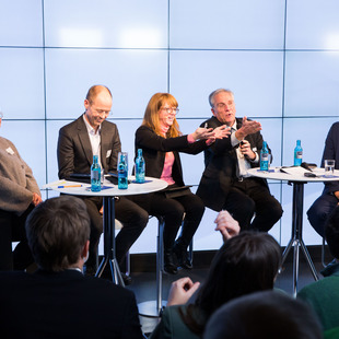 die 5 Panelisten sitzen auf dem Podium und diskutieren