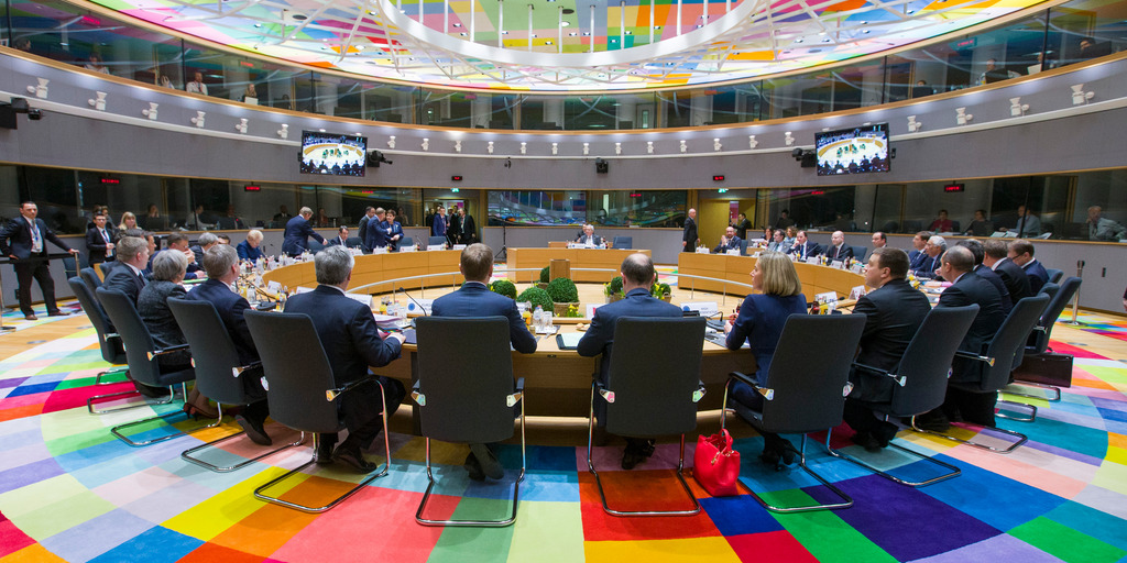 Zu sehen ist der europäische Rat in Brüssel. Es sind viele Menschen um einen Tisch versammelt.