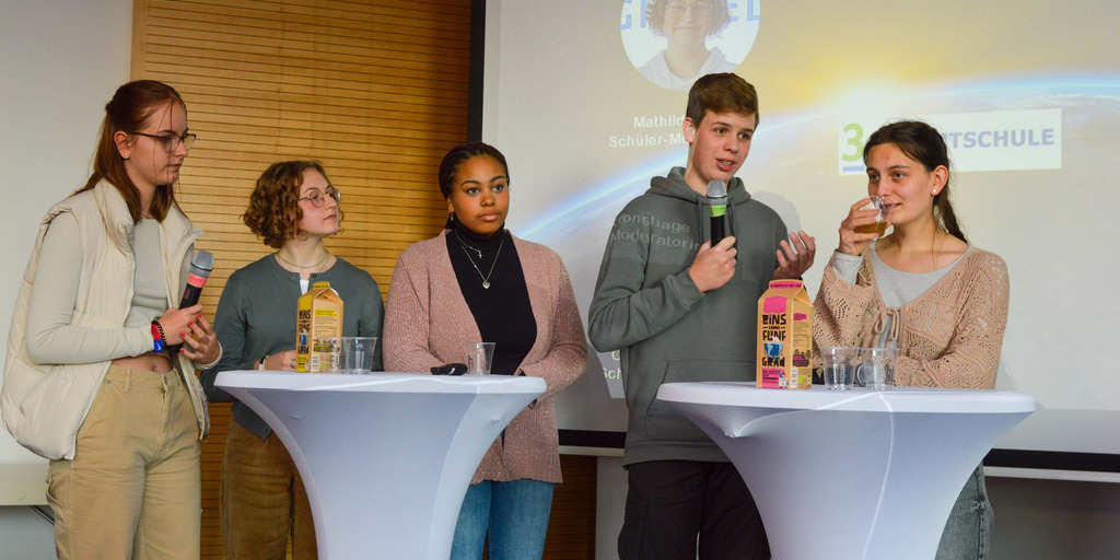 Schüler-Klima-Gipfel in der Stadthalle Gütersloh, auf dem Podium stehen mehrere Schüler und diskutieren