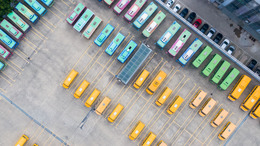Top-down aerial view into a bus depot.
