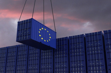 A freight container with the EU flag hangs in front of many blue stacked freight containers