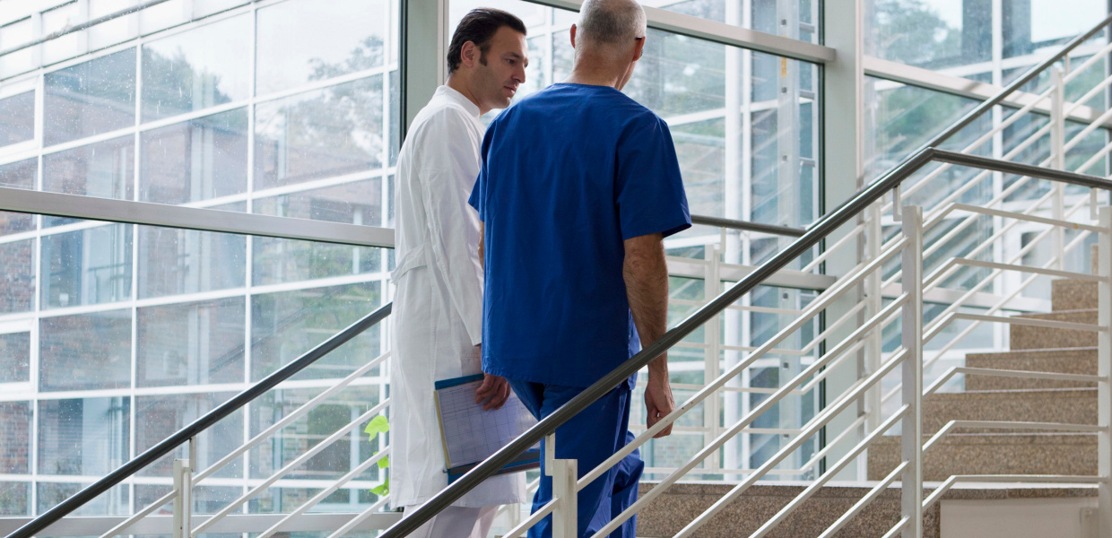 Coverbild Spotlight Krankenhaus und für die Studie Faktencheck Gesundheit Krankenhausstrukturen.
Ein Arzt und ein Pfleger gehen die Treppe in einem Krankenhaus hoch.