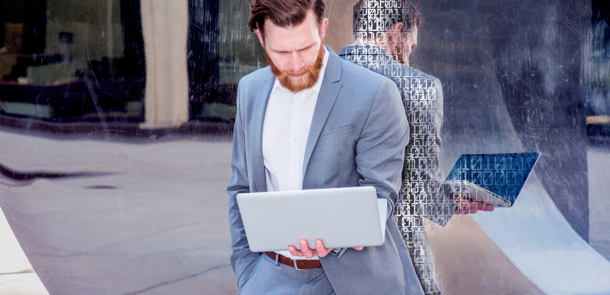 Keyvisual: Ethik der Algorithmen; bearbeitet/Retusche mit 0 und 1; American Businessman with beard, mustache works in New York. Young man wearing cadet blue suit, stands against metal mirror wall, looks down, reads on laptop computer. Filtered look with purple tint.; Shutterstock ID 520256158; Purchase Order: Ethik der Algorithmen; Job: 103-63133-131; Client/Licensee: Bertelsmann Stiftung; Other: ST-IFT  21.11.2017