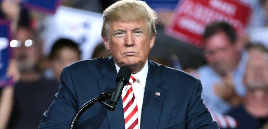 Donald Trump steht bei einer Wahlkampfveranstaltung hinter dem Rednerpult und macht ein grimmiges Gesicht.