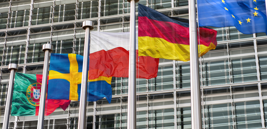 Die Flaggen Portugals, Schwedens, Polens, Deutschlands und der Europäischen Union wehen nebeneinander an Flaggenmasten.