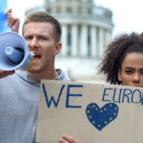 Junge Demonstranten mit Megaphon und Love Europe-Schild.