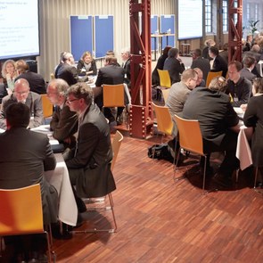 Menschen diskutieren an runden Tischen